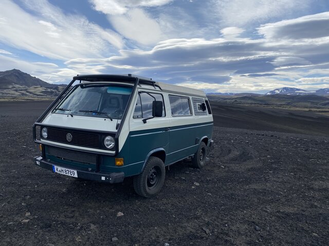 Van auf schwarzem Lavasand in Island